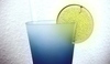 Snímek modré sklenice s limetkou přes okraj