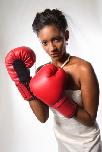 Fotografie ženy ve svatebních šatech s boxerskými rukavicemi