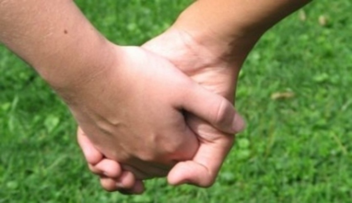 Detailní snímek zachycující pár držící se za ruce