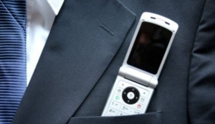 Fotografie mobilního telefonu, který je zastrčen v klopě od pánského obleku