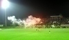 Fotografie fotbalového hřiště s kouřem v pozadí