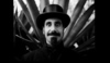 Serj Tankian na černobílé fotografii s cylindrem nahlavě