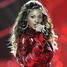 Beyoncé v červeném outfitu s mikrofonem v ruce