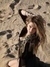 Kesha Sebert klečí na písku