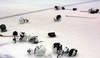 Snímek zachycující ležící přilby a hokejky na ledu