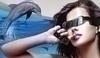 Žena ve slunečních brýlích s delfínem v pozadí
