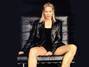 Herečka Heather Locklear sedící na černé křesle v černé kožené bundě