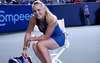 Tenistka Caroline Wozniacki v modrých šatech sedící na židli