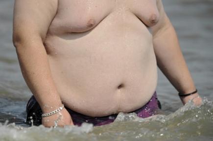 Obézní muž stojící ve vodě